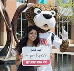 南Paw and a 美国 Student hold a sign that states: 我们是 Accepting